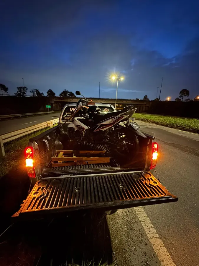 Motosikal diangkut dengan pikap tunda pada waktu malam di bawah jejambat