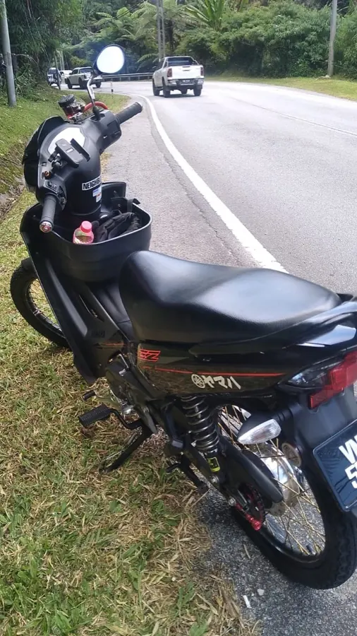 Motosikal menunggu bantuan di tepi jalan gunung